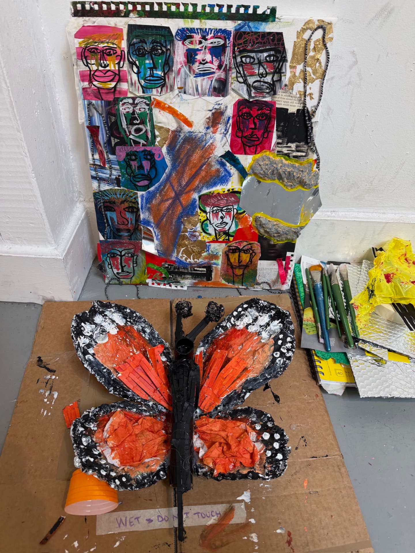 Trapped in progress, with its butterfly form beside a panel of layered abstract faces